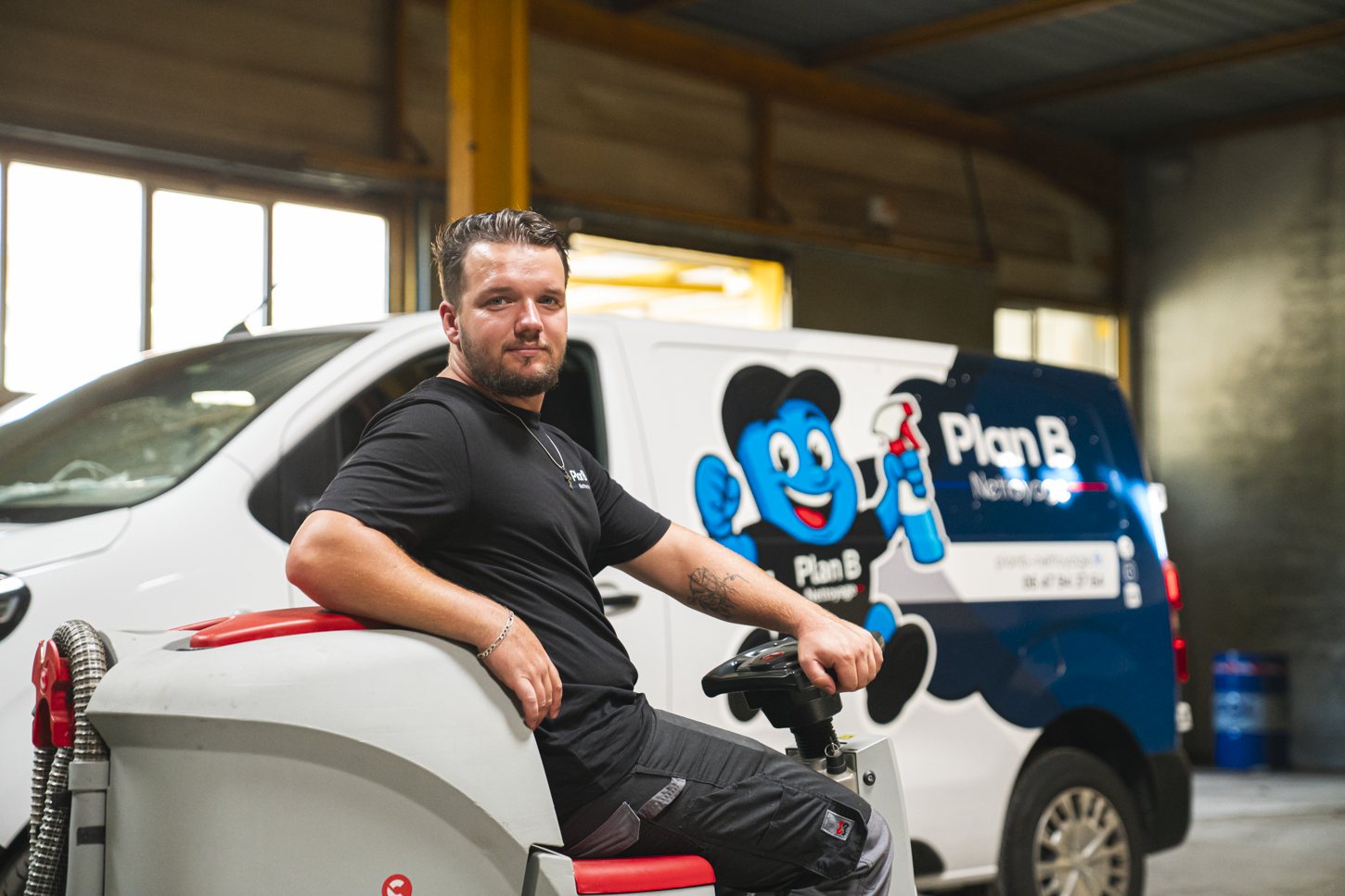 Membre de l'équipe Plan B Nettoyage devant le véhicule de l'entreprise